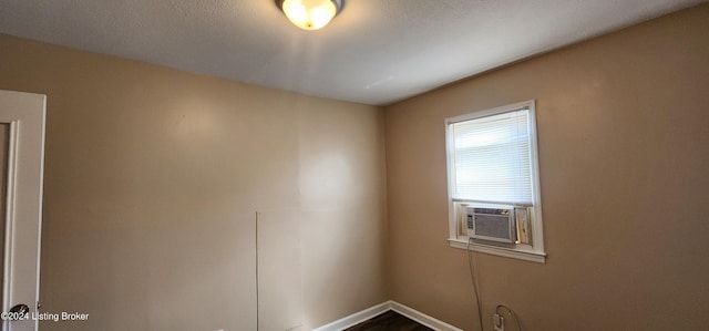 empty room featuring wood-type flooring and cooling unit