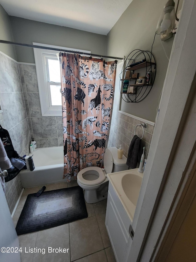 full bathroom with tile patterned floors, vanity, tile walls, toilet, and shower / bath combo with shower curtain