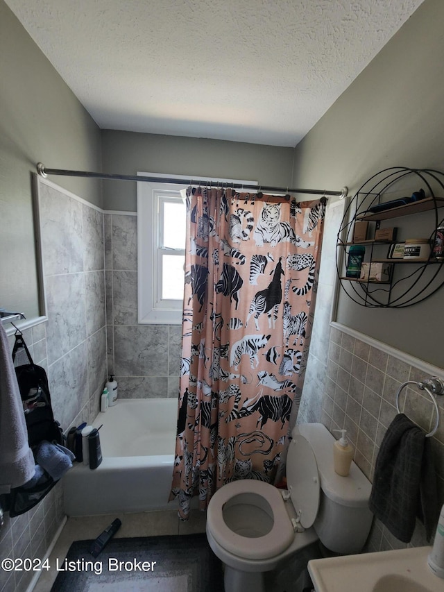 bathroom featuring a textured ceiling, toilet, tile walls, and shower / bathtub combination with curtain