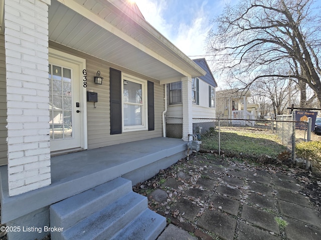 entrance to property with fence and a porch