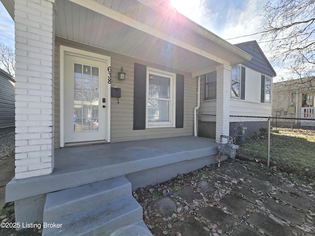 property entrance with fence and a porch