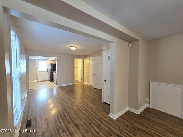 spare room with visible vents, baseboards, and wood finished floors