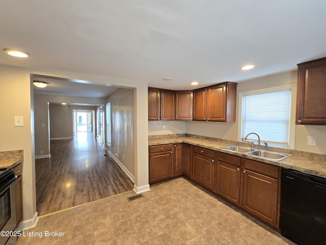 kitchen featuring baseboards, black dishwasher, visible vents, and a sink