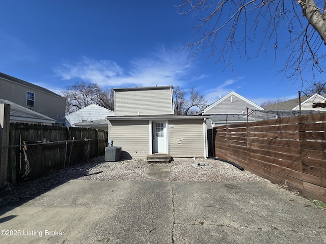 back of property with entry steps, central AC unit, an outdoor structure, and a fenced backyard