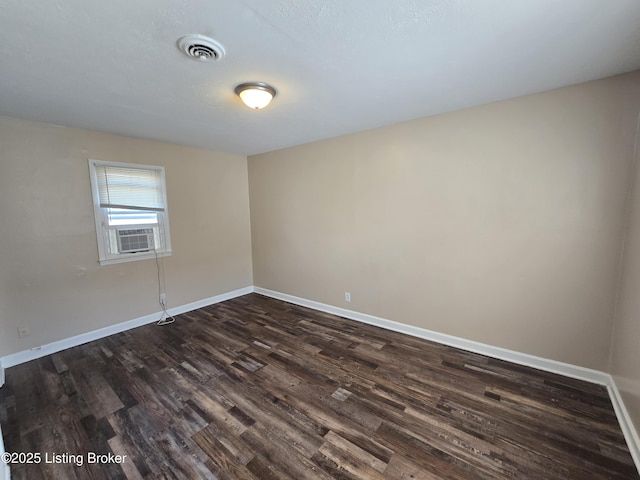 unfurnished room featuring dark wood-style floors, baseboards, and visible vents