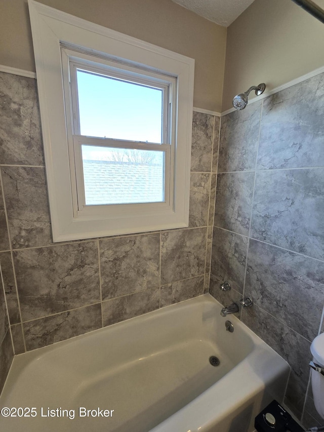 bathroom featuring shower / bathtub combination and toilet