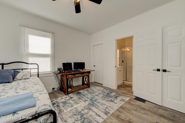 bedroom featuring ceiling fan, ensuite bathroom, and light hardwood / wood-style flooring