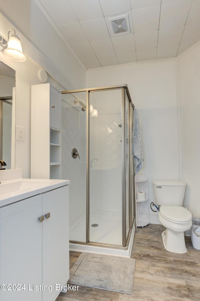 bathroom featuring vanity, hardwood / wood-style flooring, a shower with door, and toilet