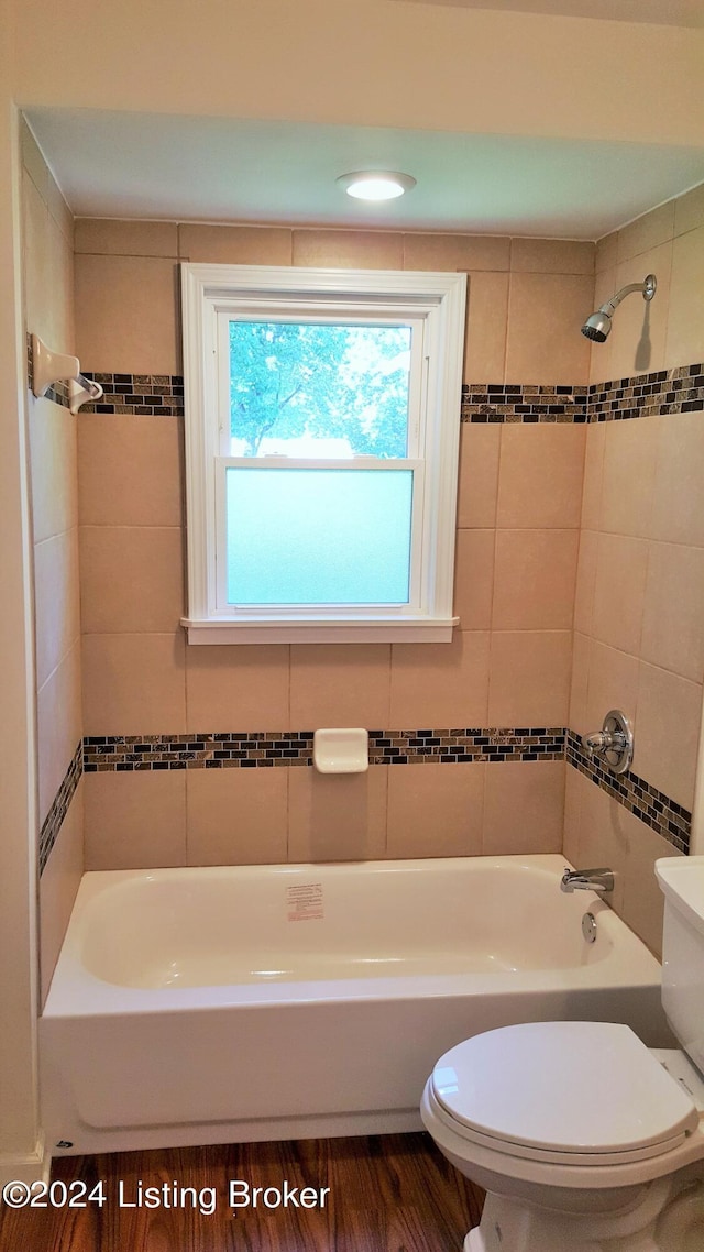 bathroom featuring toilet, tiled shower / bath, and wood-type flooring