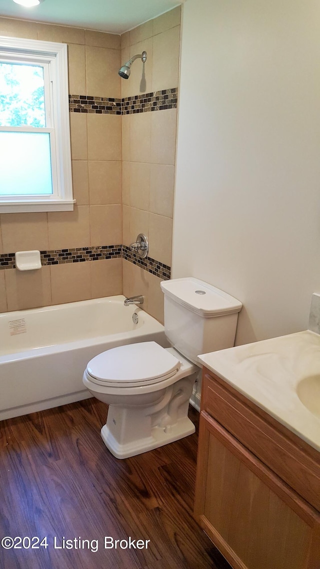 full bathroom featuring wood-type flooring, toilet, vanity, and tiled shower / bath