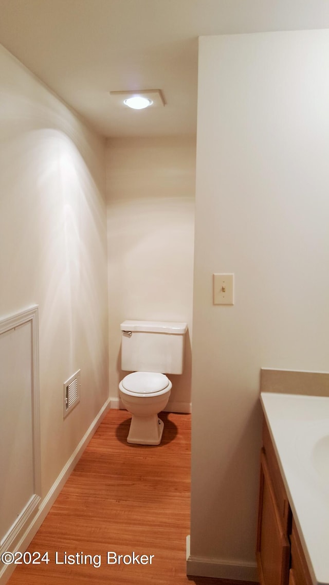 bathroom with vanity, toilet, and wood-type flooring