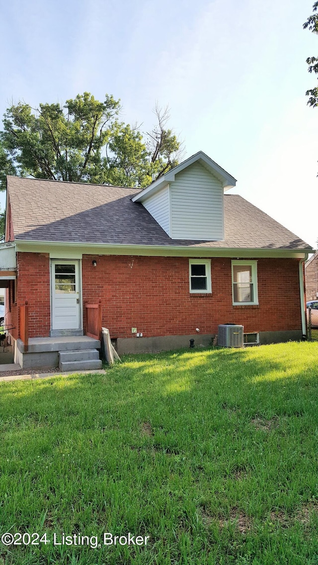 rear view of house with a yard and central AC