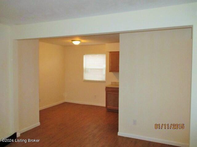 unfurnished room with dark hardwood / wood-style flooring