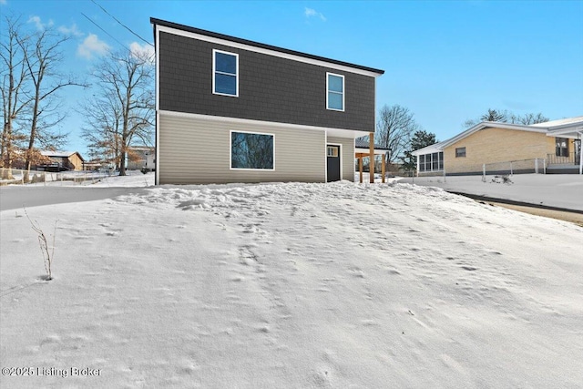 view of snow covered back of property