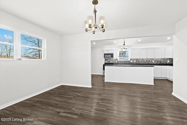 kitchen with white cabinetry, appliances with stainless steel finishes, a chandelier, and decorative light fixtures