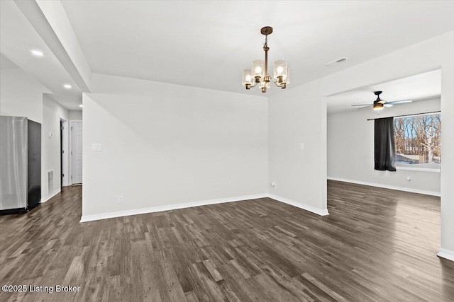 empty room with dark wood-type flooring and a notable chandelier