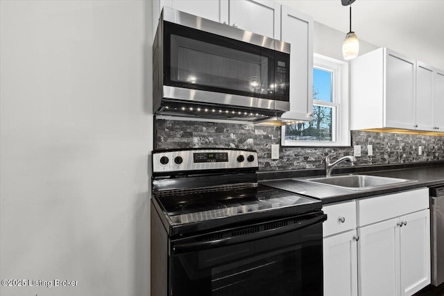 kitchen featuring backsplash, sink, white cabinets, and appliances with stainless steel finishes