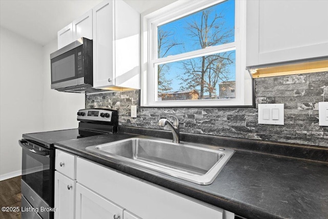 kitchen with stainless steel appliances, white cabinetry, plenty of natural light, and sink