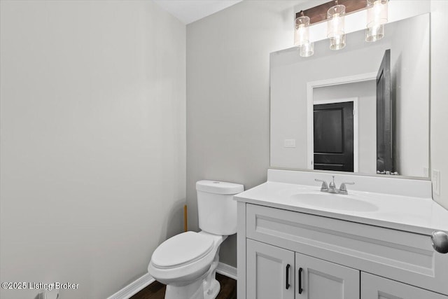 bathroom featuring vanity, wood-type flooring, and toilet