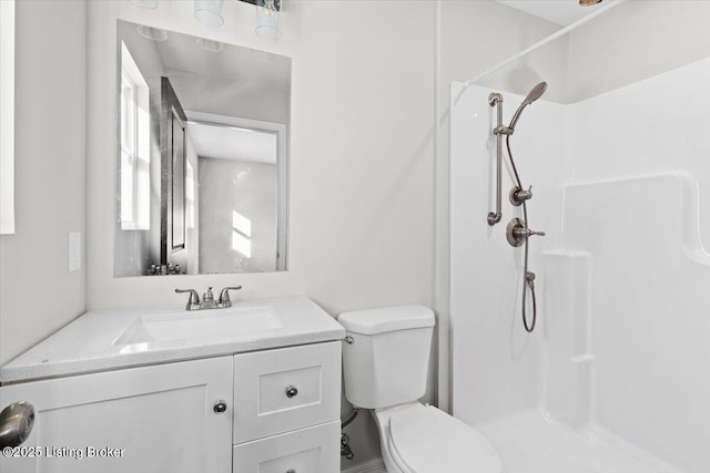 bathroom with vanity, toilet, and a shower