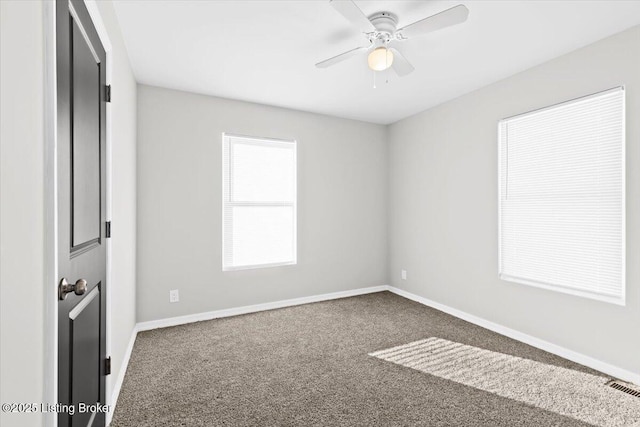 unfurnished room with ceiling fan and dark colored carpet