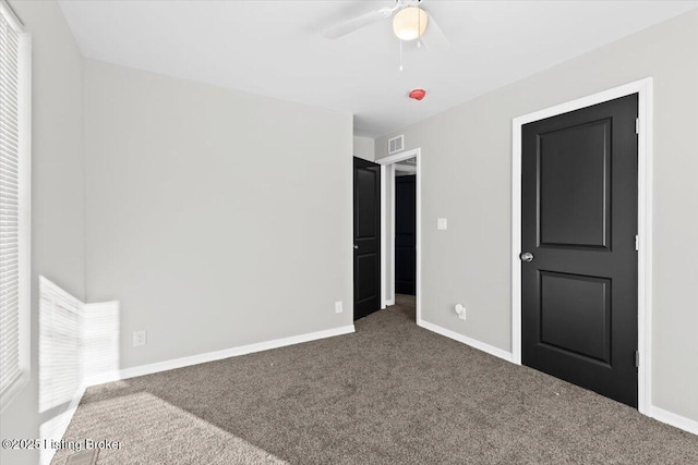 unfurnished bedroom with dark carpet and ceiling fan