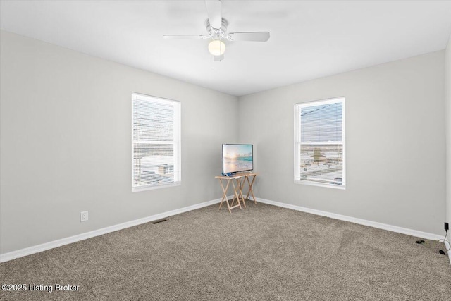 carpeted empty room featuring a healthy amount of sunlight and ceiling fan