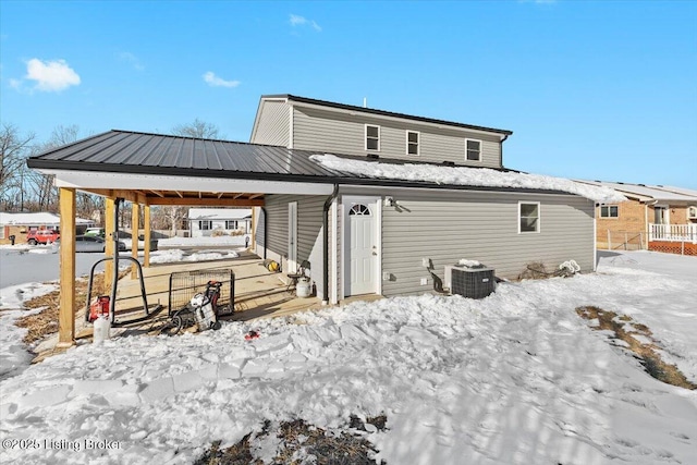 snow covered rear of property with central air condition unit