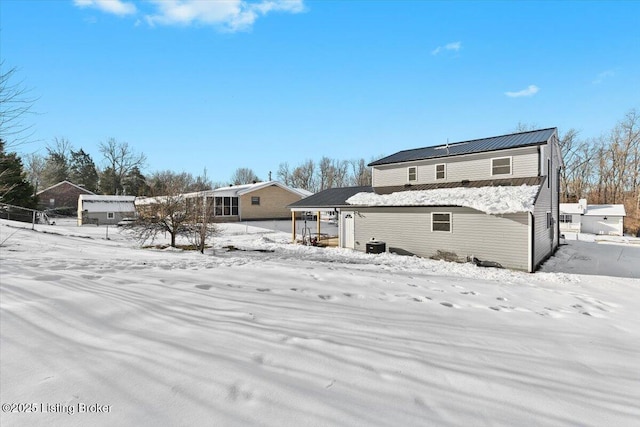 snow covered back of property featuring central air condition unit