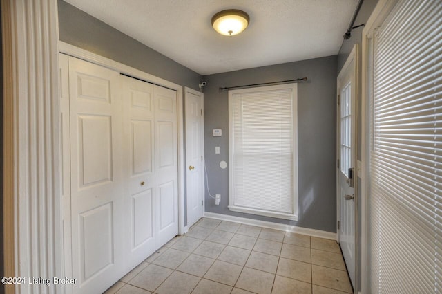 entryway featuring a textured ceiling and light tile patterned floors