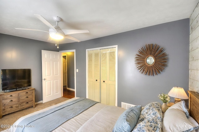 carpeted bedroom with ceiling fan and a closet