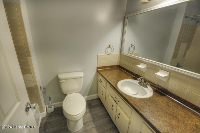 bathroom featuring vanity, hardwood / wood-style flooring, tasteful backsplash, and toilet