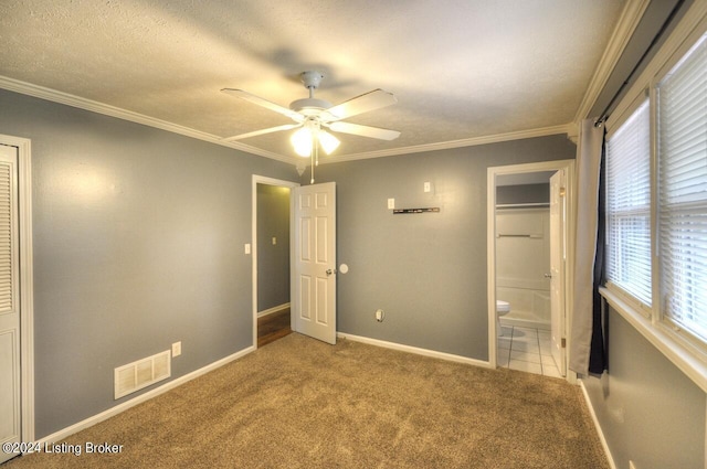 unfurnished bedroom featuring ceiling fan, connected bathroom, ornamental molding, and carpet flooring