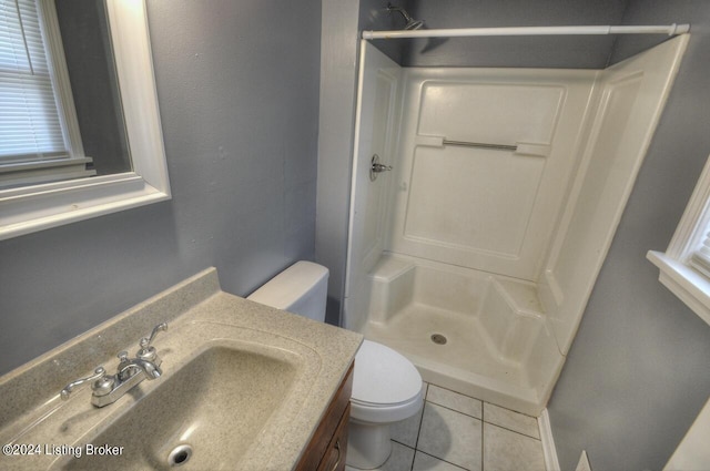 bathroom with tile patterned floors, walk in shower, toilet, and vanity