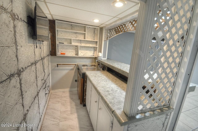 kitchen featuring sink, white cabinetry, and a paneled ceiling