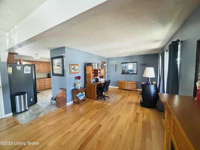 office space featuring light wood-type flooring and a textured ceiling