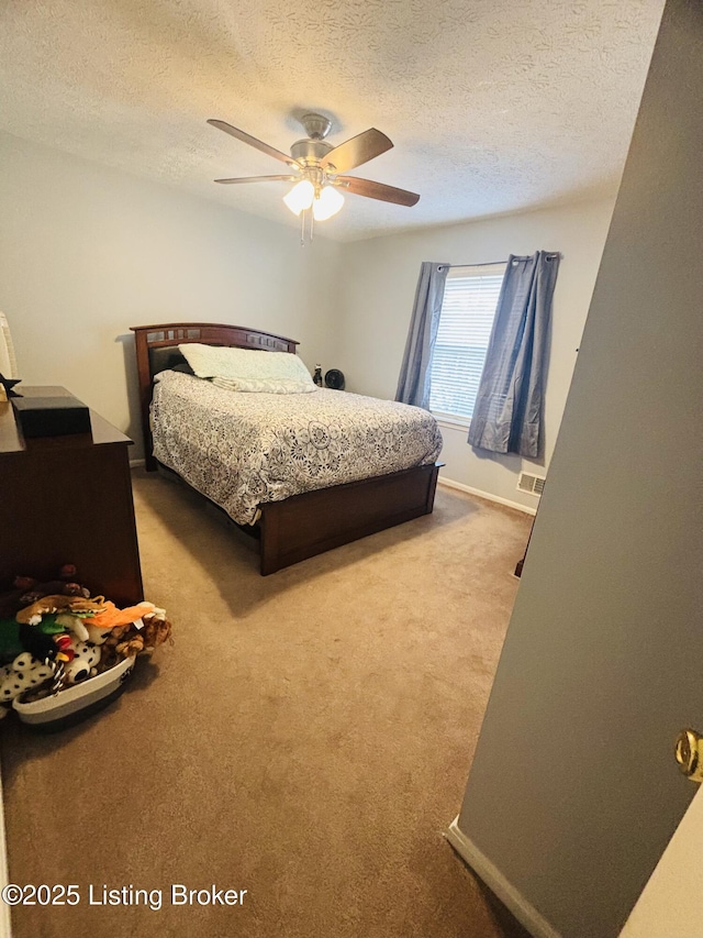 bedroom featuring ceiling fan, a textured ceiling, and carpet floors