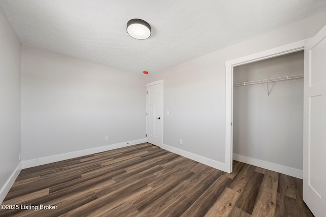 unfurnished bedroom featuring dark hardwood / wood-style floors and a closet