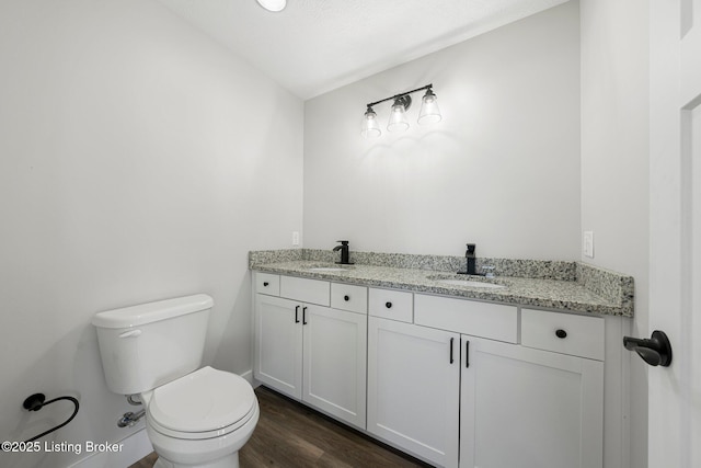 bathroom with hardwood / wood-style floors, toilet, vaulted ceiling, and vanity