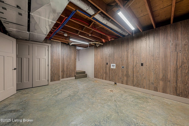 basement featuring wood walls