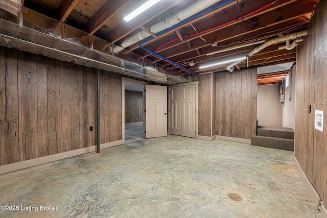 basement featuring wooden walls