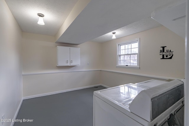 laundry room featuring cabinets, separate washer and dryer, and a textured ceiling