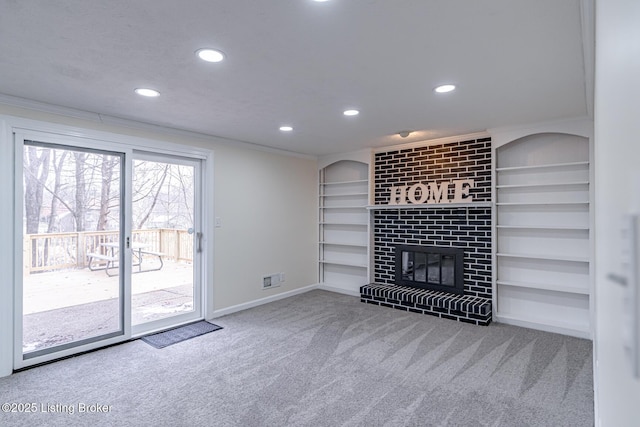 unfurnished living room featuring a fireplace, built in features, carpet floors, and crown molding