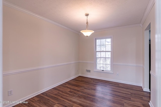 empty room featuring a textured ceiling, dark hardwood / wood-style flooring, and crown molding