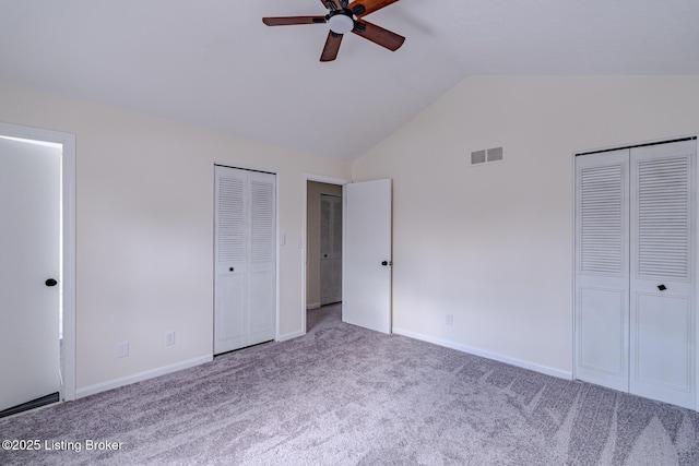 unfurnished bedroom featuring multiple closets, ceiling fan, carpet floors, and lofted ceiling