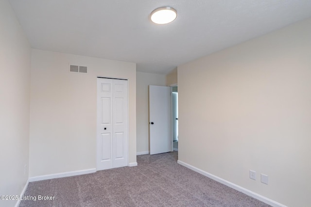 unfurnished bedroom featuring a closet and light carpet