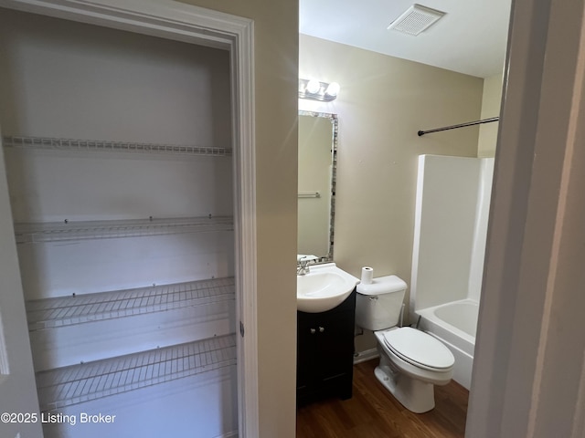 full bathroom featuring hardwood / wood-style flooring, shower / bath combination, toilet, and vanity