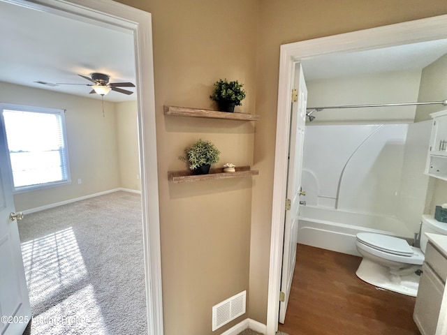 full bathroom featuring ceiling fan, shower / washtub combination, hardwood / wood-style floors, toilet, and vanity