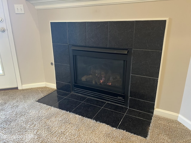 interior details with carpet and a tiled fireplace