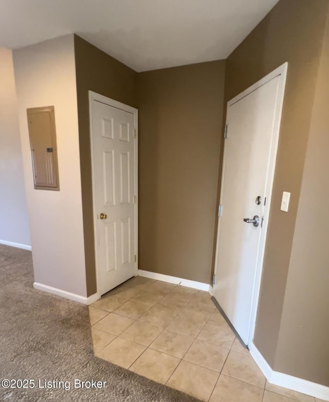 corridor with light tile patterned flooring and electric panel